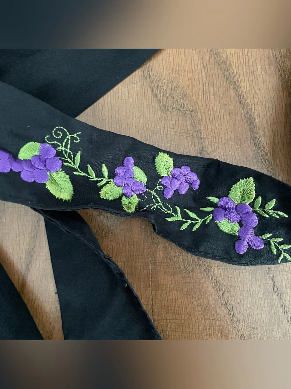Black cloth hair scarf with purple floral embroidery and green leaves